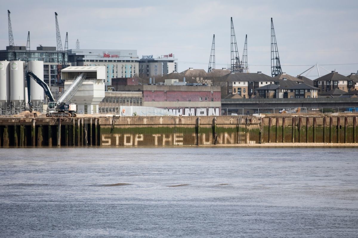 Activists jet-washed the slogan stop the tunnel onto the Thames embankment near the tunnels proposed location