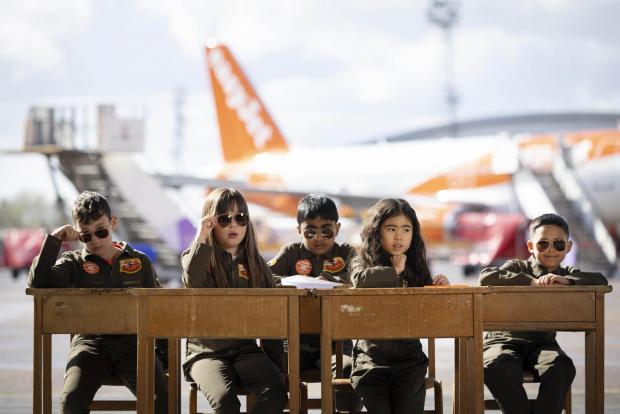 Tottenham Independent: Sam Bennett, aged 12, Olivia Joohee-Riddington, aged 9, Arjun Giri, aged 9, Rei Diec, aged 7 and Rico Jeerasinghe, aged 9 during filming of a parody of the movie Top Gun at Luton airport as part of easyJet's nextGen recruitment campaign. Credit: PA/easyJet